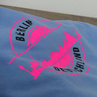 Hellblaues T-Shirt mit leuchtendem, pinkem Druck der Berliner Skyline und dem Schriftzug "DEUTSCHLAND". Eine kreative Verwendungsmöglichkeit mit der Stempel Skyline Berlin Plotterdatei von easy-sticks.