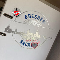 Ein Detailfoto eines weißen Ordners, verziert mit dem Design "Stempel Skyline Dresden" von easy-sticks, perfekt als Plotterdatei.