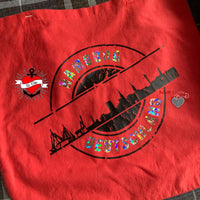 Eine rote Tasche, verziert mit der Hamburg Skyline, entworfen mit der "Stempel Skyline Hamburg" Plotterdatei von easy-sticks, ideal für kreative Bastelarbeiten.