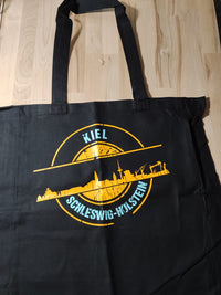 Eine stilvolle schwarze Tragetasche mit dem Druck der "Stempel Skyline Kiel" Plotterdatei von easy-sticks, ideal für kreatives Gestalten.