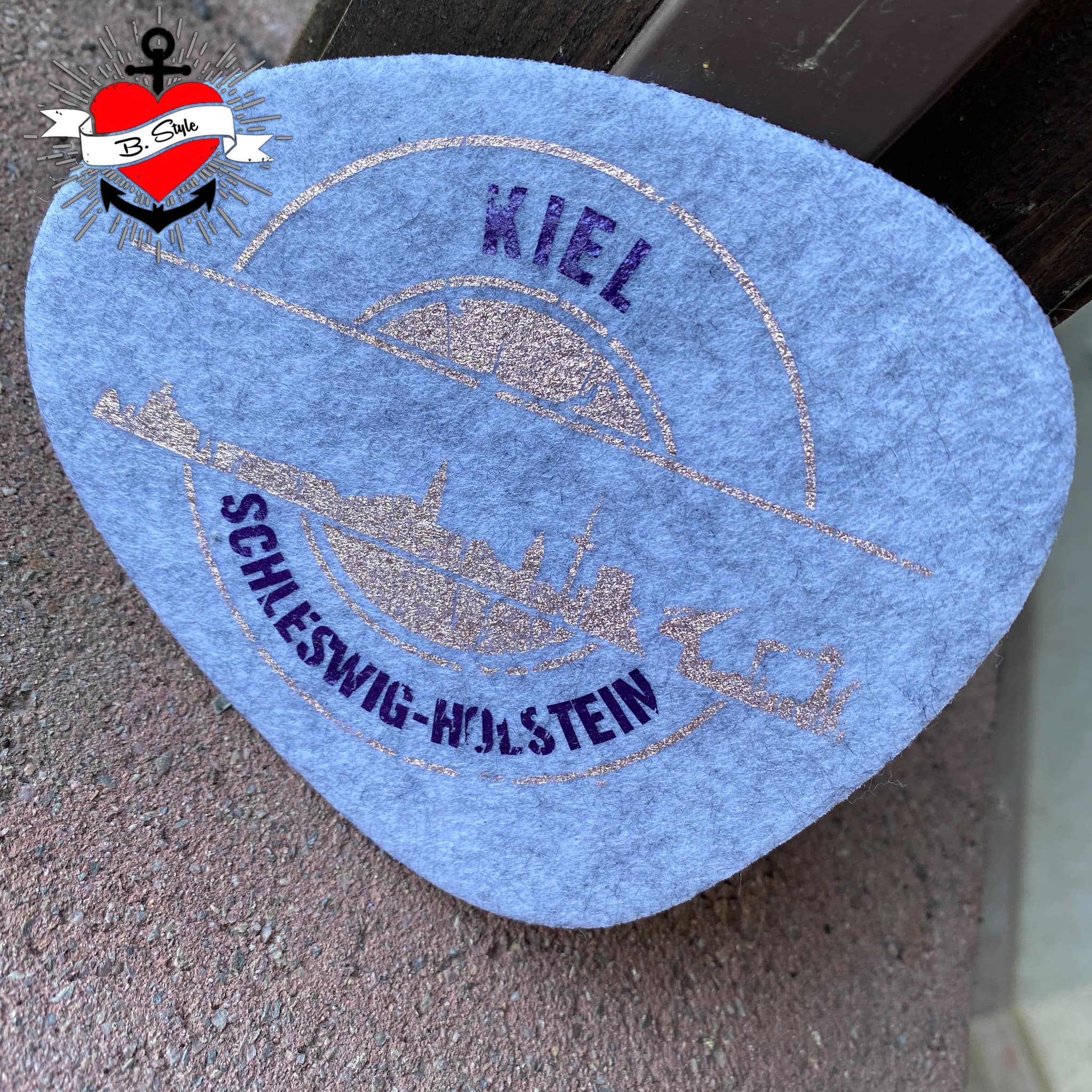 Filzuntersetzer in sanftem Blau mit dem Design 'Stempel Skyline Kiel' von easy-sticks, hergestellt mit der Plotterdatei für individuelle Kreationen.