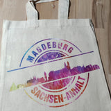 Eine wiederverwendbare Tragetasche mit dem bunten Motiv "Stempel Skyline Magdeburg" von easy-sticks, inspiriert von der Plotterdatei für kreative Bastelprojekte.