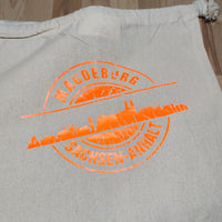 Schnappschuss der Stempel Skyline Magdeburg Plotterdatei von easy-sticks auf einer farbigen Stofftasche. Die Grafik zeigt die Skyline von Magdeburg, ideal für kreative DIY-Projekte mit dieser Plotterdatei.