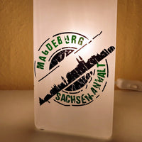Eine kreative Lampe mit dem Design "Stempel Skyline Magdeburg" von easy-sticks, die aus der einzigartigen Plotterdatei erstellt wurde. Ideal für individuelle Projektideen.