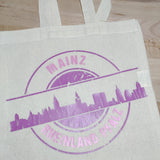 Die Stempel Skyline Mainz Plotterdatei von easy-sticks auf einer Baumwolltasche in lila, ideal für kreative DIY-Projekte.