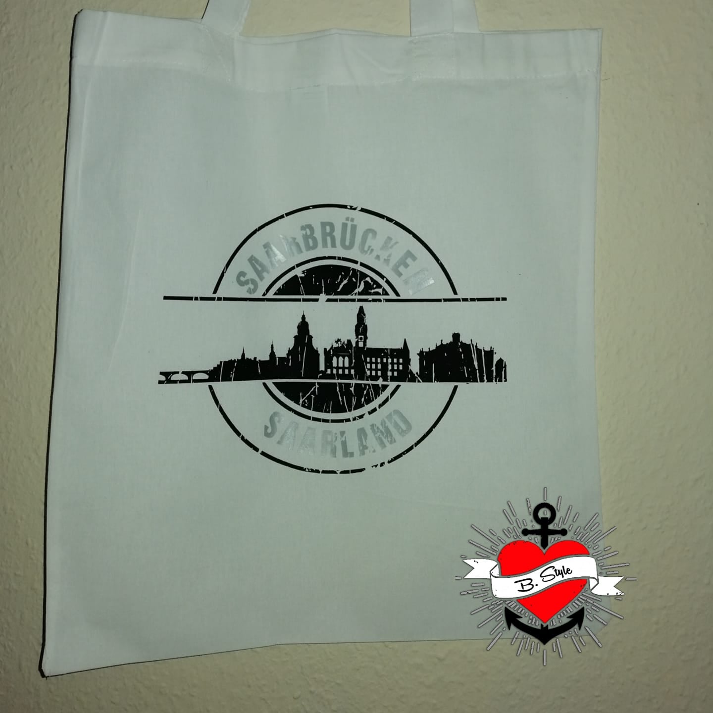 Weiße Tragetasche mit schwarz-weißer Skyline von Saarbrücken, perfekt für individuelle Designs mit der 'Stempel Skyline Saarbrücken' Plotterdatei von easy-sticks.