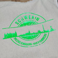 Eine leuchtend grüne Darstellung der "Stempel Skyline Schwerin" Plotterdatei von easy-sticks auf einer Tragetasche. Perfekt für DIY-Projekte.