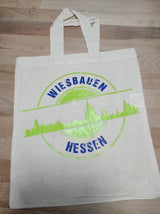 Eine nachhaltige Tragetasche, verziert mit der Skyline Wiesbaden Plotterdatei von easy-sticks, zeigt das dynamische Design 'WIESBADEN HESSEN' in leuchtendem Grün.