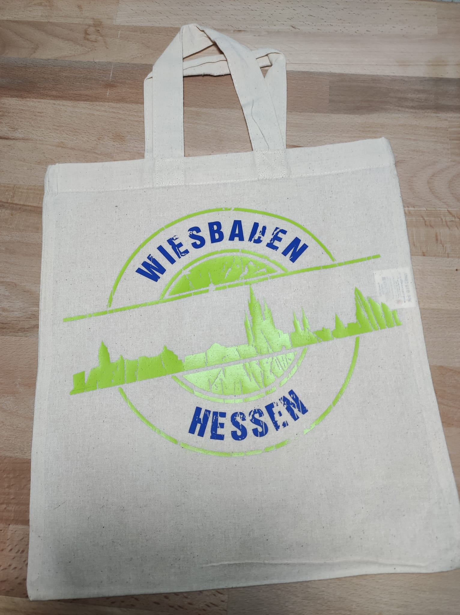 Eine nachhaltige Tragetasche, verziert mit der Skyline Wiesbaden Plotterdatei von easy-sticks, zeigt das dynamische Design 'WIESBADEN HESSEN' in leuchtendem Grün.