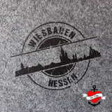 Das stilvolle Design der Skyline Wiesbaden Plotterdatei von easy-sticks auf einem grauen Stoff, präsentiert den Schriftzug 'WIESBADEN HESSEN' in einem eleganten Schwarz.