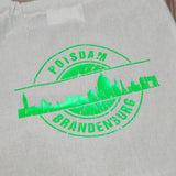 Lebendige grüne Folienanwendung des Stammes Skyline Potsdam von easy-sticks, die die ikonische Skyline von Potsdam auf einem hellen Stoff präsentiert, perfekt für individuelle Kreationen mit der Plotterdatei.