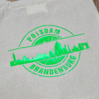 Lebendige grüne Folienanwendung des Stammes Skyline Potsdam von easy-sticks, die die ikonische Skyline von Potsdam auf einem hellen Stoff präsentiert, perfekt für individuelle Kreationen mit der Plotterdatei.