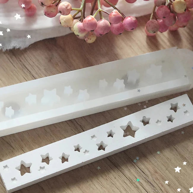 Handgefertigte Easy-Sticks Silikonform von Easy-Sticks mit Sternen-Motiven, ideal für kreative Winter- und Weihnachtsdeko. Zeigt zwei Silikonformen auf einem Holzuntergrund, umgeben von dekorativen Zweigen.
