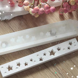Handgefertigte Easy-Sticks Silikonform von Easy-Sticks mit Sternen-Motiven, ideal für kreative Winter- und Weihnachtsdeko. Zeigt zwei Silikonformen auf einem Holzuntergrund, umgeben von dekorativen Zweigen.