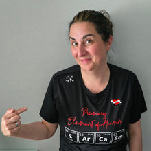 Lade das Bild in den Galerie-Viewer, Begeisterte Person trägt ein Shirt mit dem Spruch &#39;Primary Element of Humor&#39;, verziert mit dem Periodensystem von easy-sticks, strahlt Freude und Kreativität aus.
