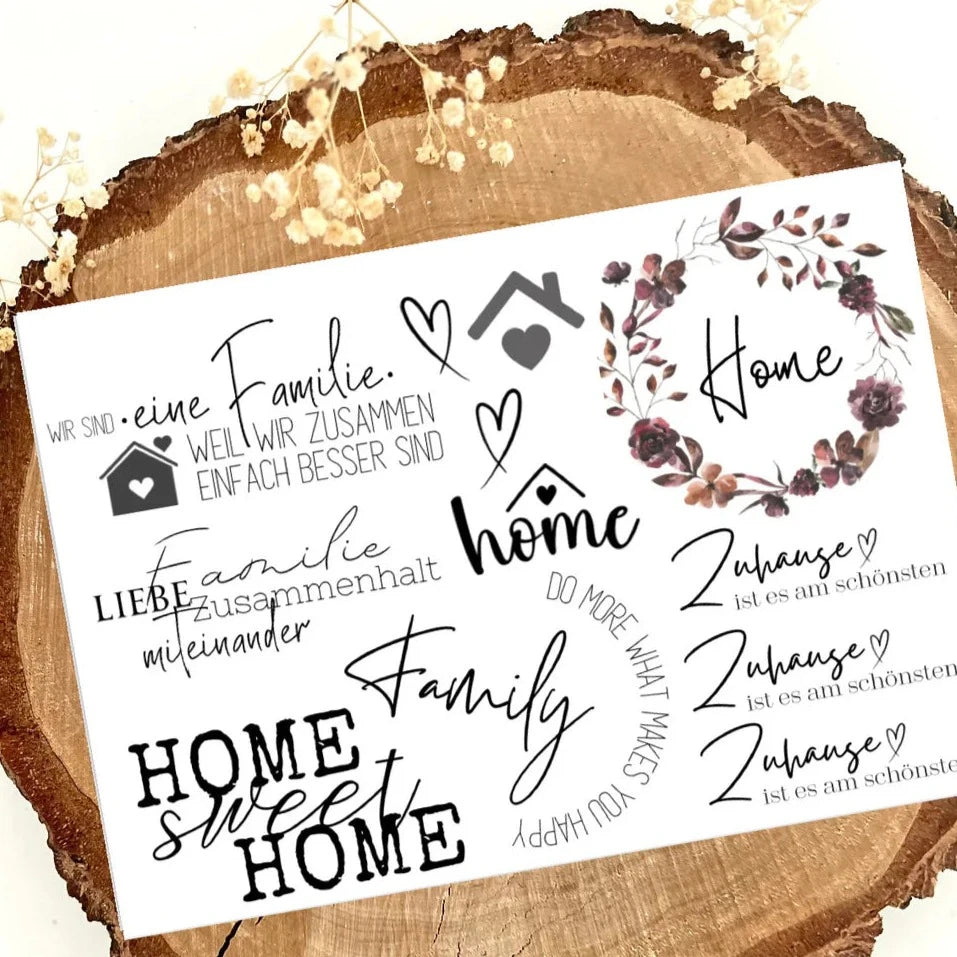 Rub on UV Sticker randlos Zuhause A5 von easy-sticks, präsentiert auf einer rustikalen Holzplatte mit schönen Schriftzügen und Motiven über Familie und das Zuhause.