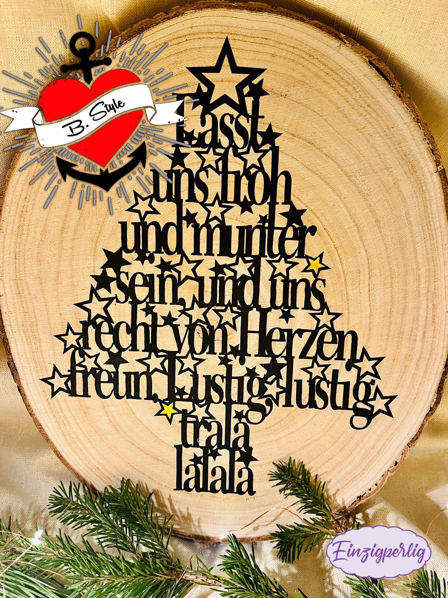 Ein stilvoller schwarzer Holz-Tannenbaum mit dem Text "Lasst uns froh und munter sein, und uns recht von Herzen freun. Lustig, lustig, trala lalala" auf einem Baumstamm, ideal für festliche Deko-Projekte von easy-sticks.