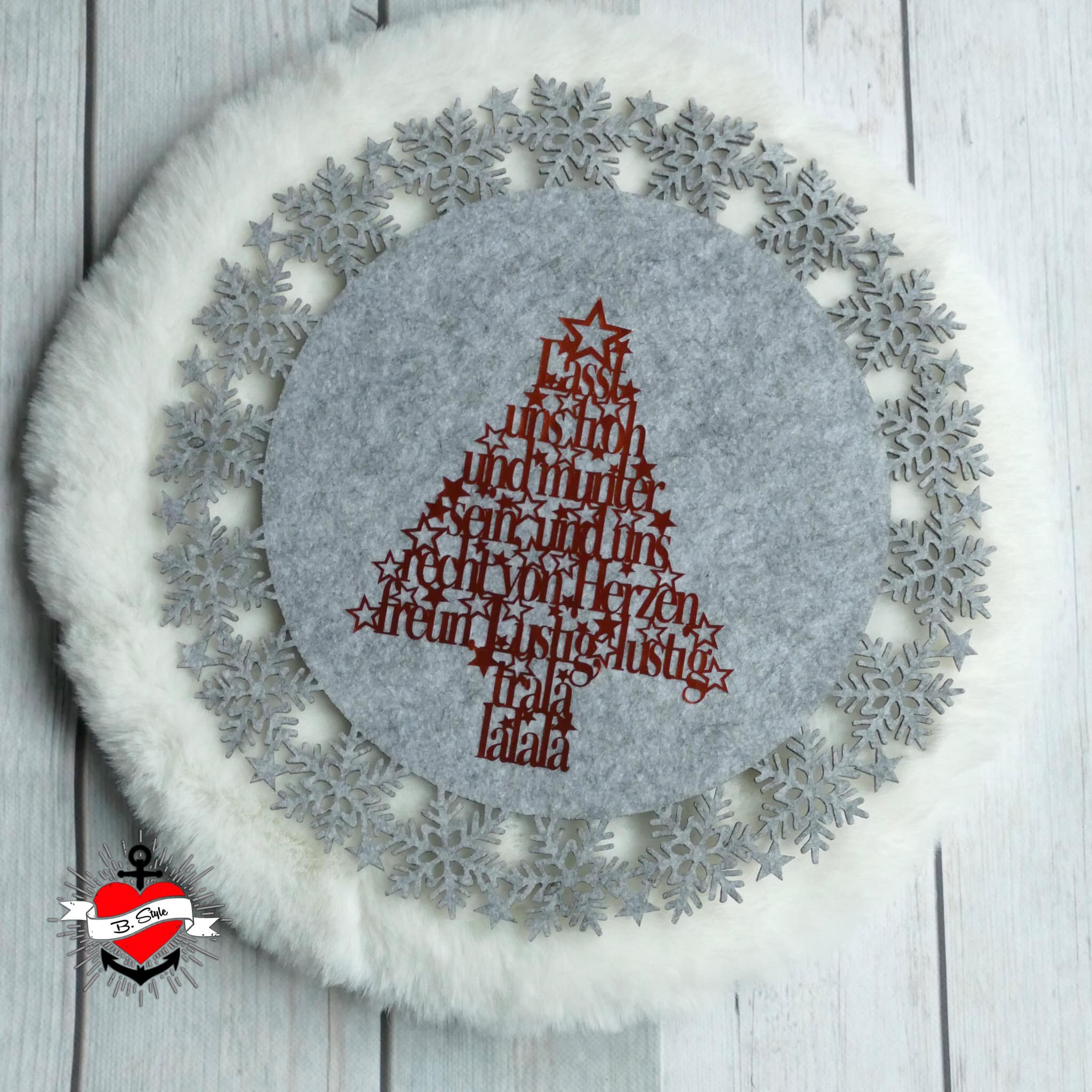 Eine festliche Weihnachtsbaum-Deko aus Filz in rot, geschmückt mit dem Spruch "Lasst uns froh und munter sein, und uns recht von Herzen freun. Lustig, lustig, trala lalala" - perfekt für DIY Dekorationen von easy-sticks.