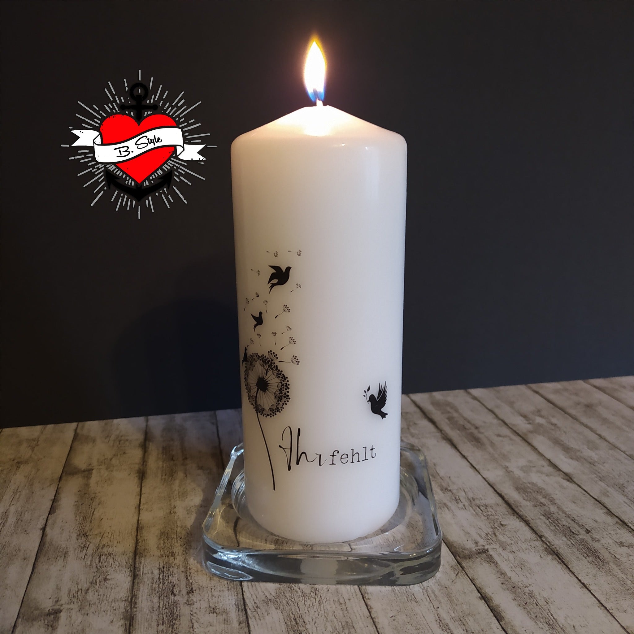 Weiße Trauerkerze von easy-sticks, dekoriert mit Dandelion- und Vogelmotiven, symbolisiert Erinnerungen und Verlust.
