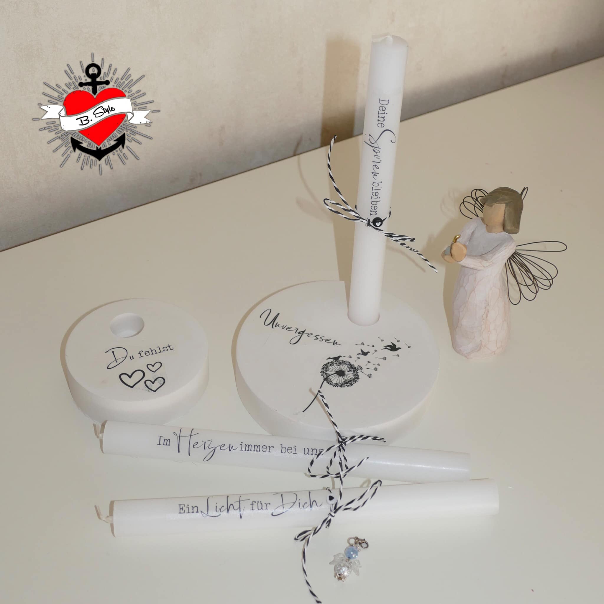 Elegantes Kerzenarrangement mit handbeschrifteten Kerzen und einer dekorativen Engel-Figur, perfekt für Gedächtnisfeiern, von easy-sticks, Trauer Plotterdatei.