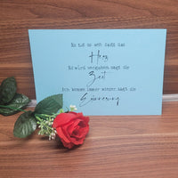 Karte auf blauem Hintergrund mit dem Text: "Es tut so weh sagt das Herz..." und einem roten Stoff-Rosenarrangement. Ideal für Trauerkarten. Trauersprüche 2 Plotter Datei und PDF Daei für Wasserschiebefolie Kerzen Gestalung von easy-sticks.