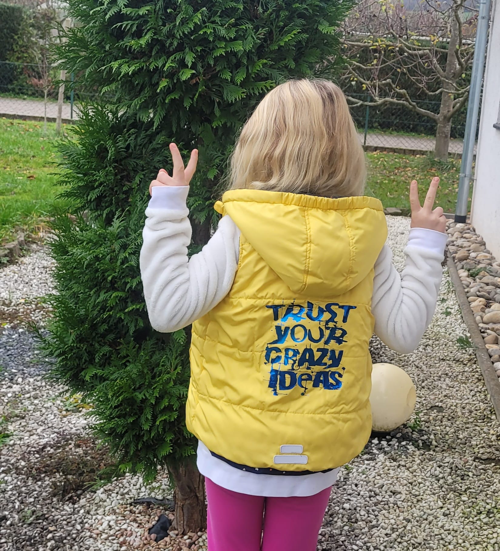 Junge mit gelber Weste, auf der 'TRUST YOUR CRAZY IDEAS' von easy-sticks steht, posiert vor einem grünen Hintergrund.