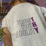Hinteransicht eines bedruckten T-Shirts für Kinder mit dem Slogan 'TRUST YOUR ABILITY' von easy-sticks, eine tolle Verwendung der Plotterdatei.