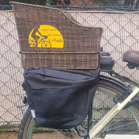 Ein stilvolles weißes Fahrrad mit einem Korb und dem Aufkleber 'Jede Fahrt ein kleiner Urlaub' von easy-sticks, auf einer grünen Wiese, perfekt für entspannte Fahrradtouren.