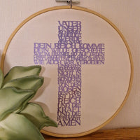 Ein hübscher gestickter Rahmen mit einem lilafarbenen Kreuz, verziert mit dem Text 'Vater Unser'. Perfekt für kreative DIY-Projekte, inspiriert durch die Vater Unser Kreuz Plotter- und Laserdatei von easy-sticks.