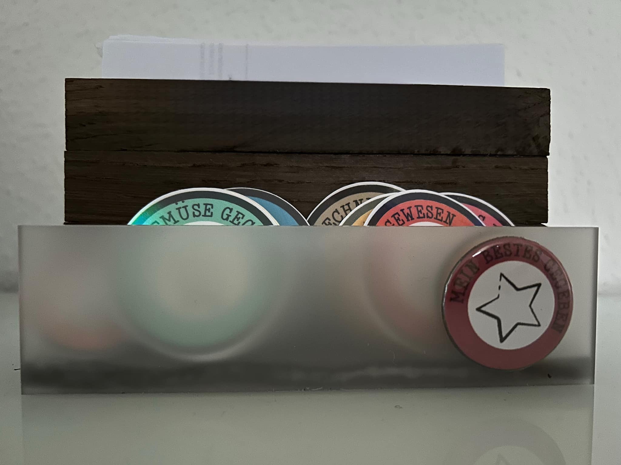 Kreatives Arrangement von Verdienstabzeichen in einem Holzspender, ideal für DIY-Projekte, inspiriert von der Plotterdatei "10 Verdienstabzeichen für Erwachsene" von easy-sticks.