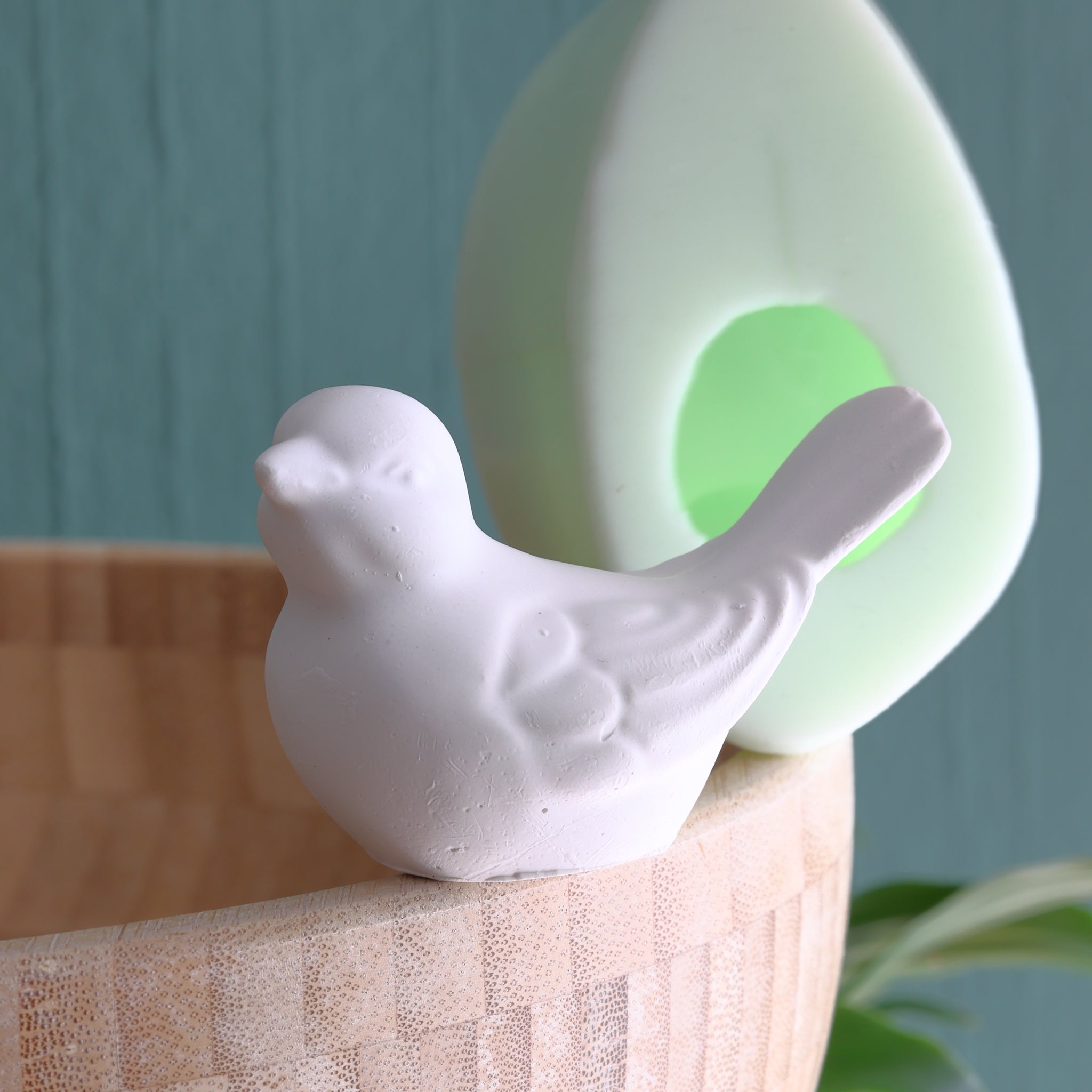 Silikonform Vogel von Easy-Sticks, abgebildet mit einer weißen Vogelstatue an einem hölzernen Gefäß im Hintergrund, ideal für kreative Bastelprojekte.
