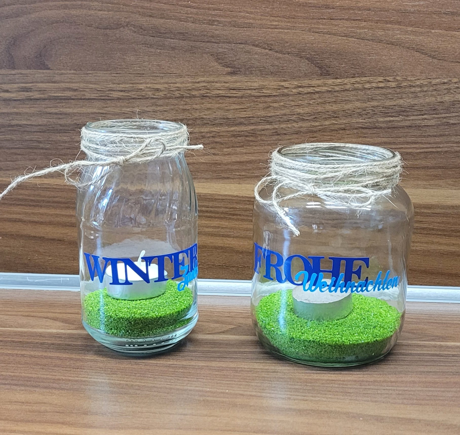 Zwei verschlossene Glasbehälter, dekoriert mit den Aufschriften 'Winter' und 'Frohe Weihnachten', gefüllt mit grüner Deko. Ein kreatives Produkt von Easy-Sticks, basierend auf der Weihnachtswörter Duo Plotter Datei.