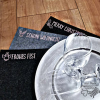 Elegant dekorierte Tischsets mit verschiedenen Weihnachtsgrüßen wie "Merry Christmas" und "Frohes Fest", inspiriert durch die Plotterdatei "Weihnachtsgrüße 1" von easy-sticks.