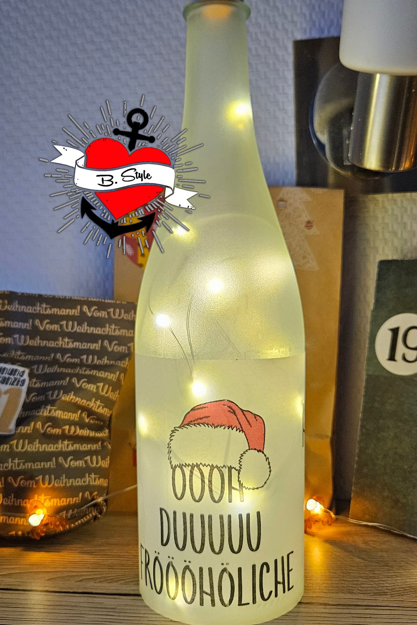 Frostfreie Flasche mit einem festlichen Licht und dem Spruch 'OOOH DUUUU FRÖÖÖHLICHE', inspiriert von der Plotterdatei von Easy-Sticks: 'Oh du fröhliche Hohoho Tannenbaum Weihnachten Weihnachtsmützen'.