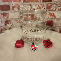 Schöne Adventszeit Kerzengestaltung mit der Plotterdatei und PDF "Weihnachtsgrüße 3" von easy-sticks. Glas mit goldener Schrift und roten Herzanhängern auf einem geschmackvollen Hintergrund.