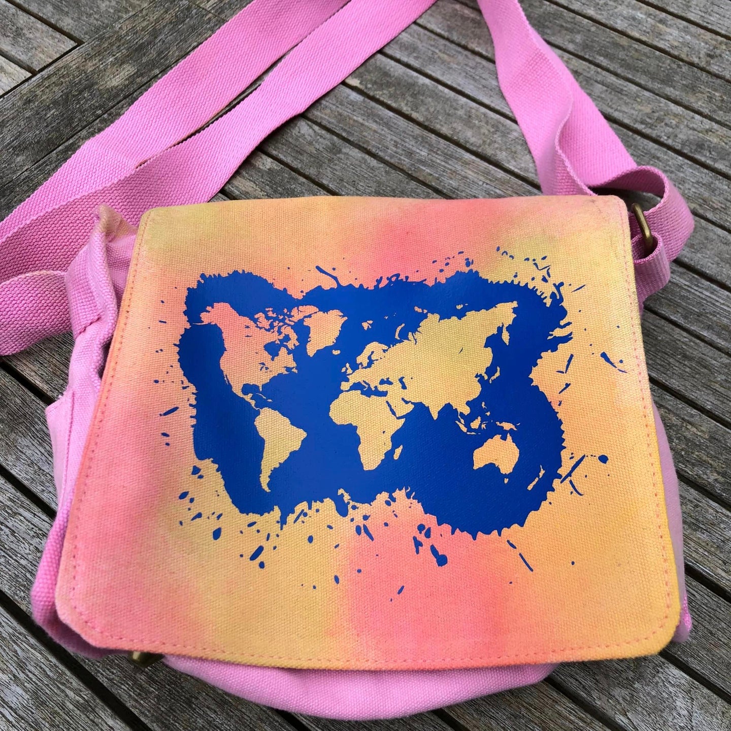 Stylische Tasche mit Weltkarte Plotterdatei von easy-sticks, in lebhaften Farben auf pinkem Hintergrund.