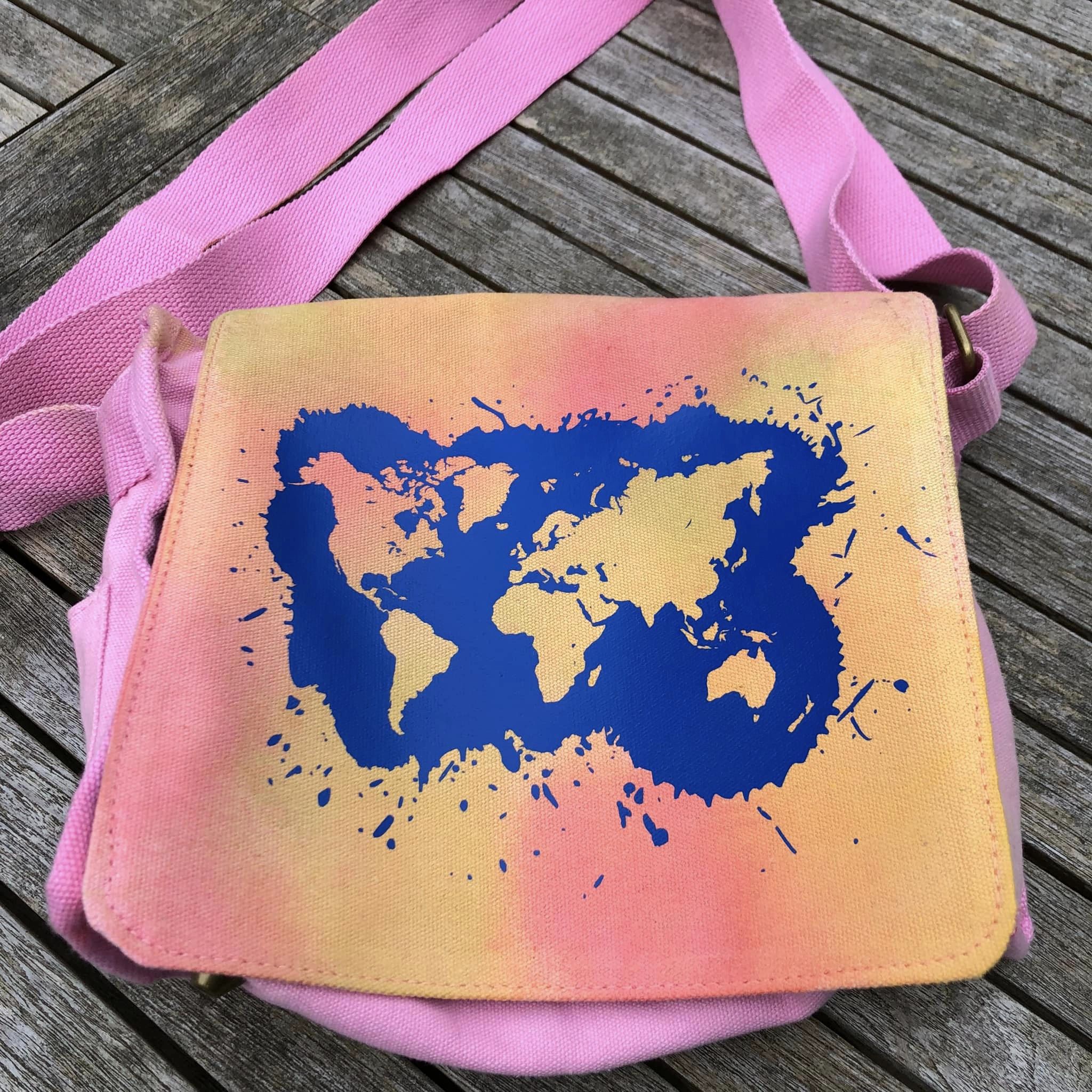 Stylische Tasche mit Weltkarte Plotterdatei von easy-sticks, in lebhaften Farben auf pinkem Hintergrund.