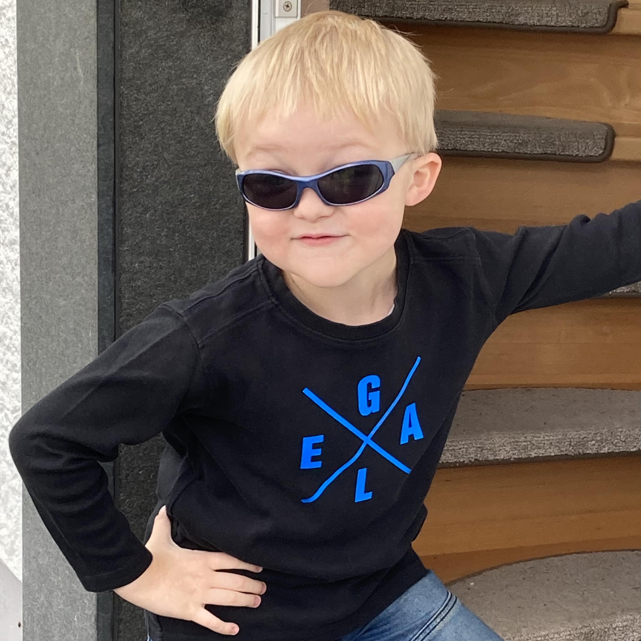 Schlauer Junge in Sonnenbrille und schwarzem Shirt mit blauem Schriftzug, inspiriert von der "X Worte" Plotterdatei von easy-sticks.