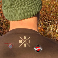 Hinteransicht eines Mannes in grüner Strickmütze mit grauem Shirt, darauf der Aufdruck "X Worte" von easy-sticks.