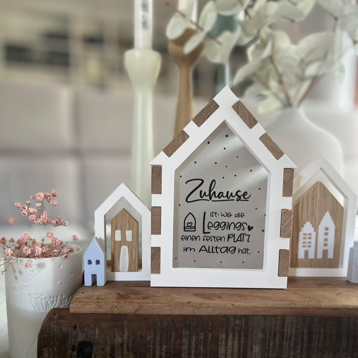 Kreative Laterne mit dem Spruch 'Zuhause ist, wo die Leggings einen festen Platz im Alltag hat.' von Easy-Sticks. Stilvolles Deko-Element in Holz- und Weißtönen, ideal für DIY-Projekte.