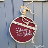 Ein stilvolles Schild mit dem Slogan 'Zuhause ist kein Ort, sondern ein Gefühl' von easy-sticks, dekorativ mit einer Schnur und an einer Holztür aufgehängt.