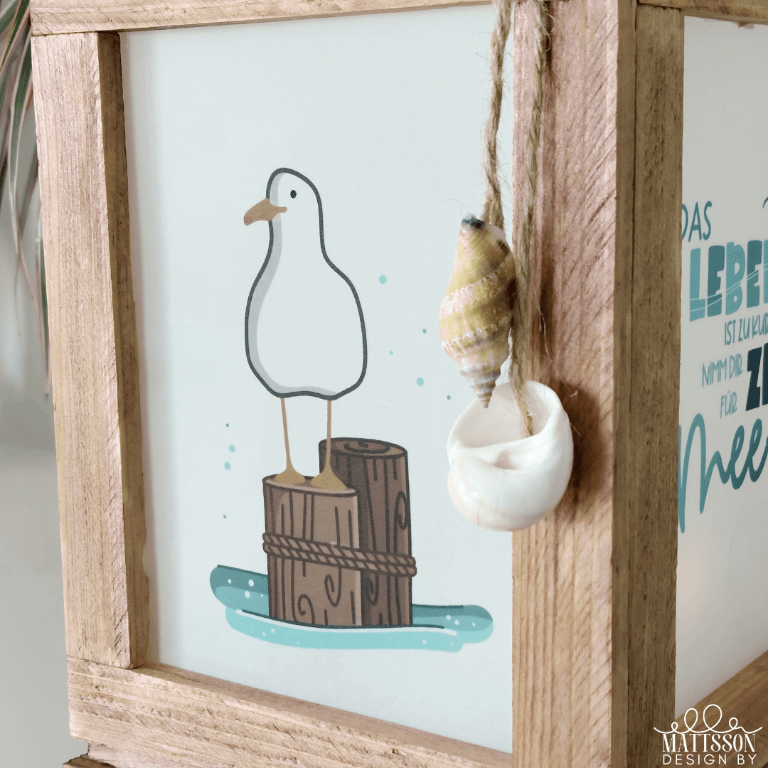 Detailaufnahme der maritimen Laterne von easy-sticks mit einer Illustration einer Möwe. Teil der 'Meer' Laterne Easy-Sticks Bastel PDF.