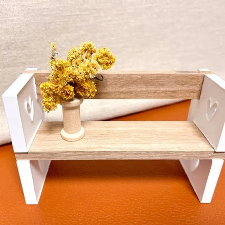 Silikon Gießform Herzsitzbank mit Lehne von easy-sticks: Eine dekorativ gestaltete Miniaturbank mit Trockenblumen, die die Form zeigt.
