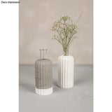 Stilvolles Wohnaccessoire von Easy-Sticks - Silikonform 'Vase geriffelt' mit einem modernen, geriffelten Design in Beton und Weiß, ideal als Vase oder Kerzenhalter, präsentiert mit zarten Blumen.