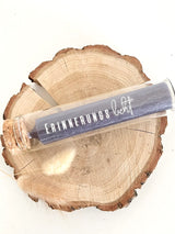 Rub On UV Sticker randlos von easy-sticks, präsentiert in einem eleganten Glasröhrchen mit dem Schriftzug 'ERINNERUNGSlicht' auf einem natürlichen Holzuntergrund.