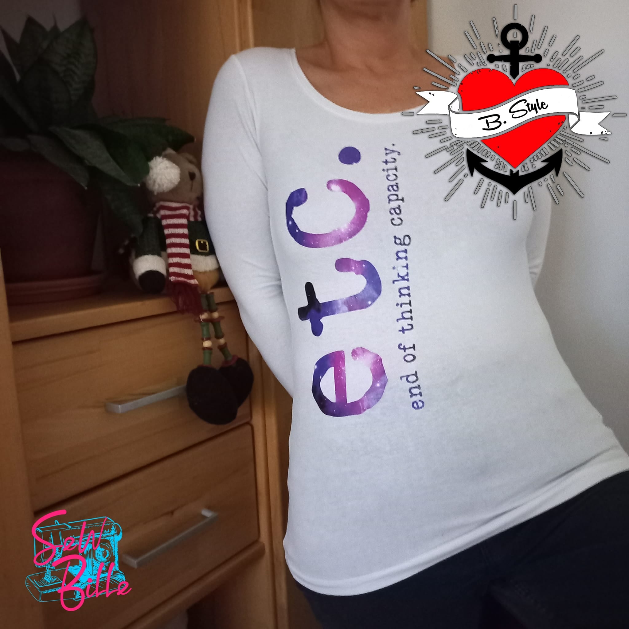 Eine Frau trägt ein weißes Langarmshirt mit dem Aufdruck "etc. end of thinking capacity." in lila und blau. Kreative Mode von easy-sticks für lässige Anlässe.