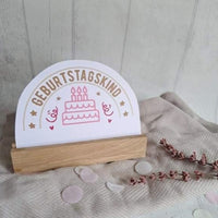Stimmungsvolle Geburtstagsdeko von easy-sticks mit dem Spruch 'Geburtstagskind', präsentiert auf einem Holzständer für besondere Feiern.