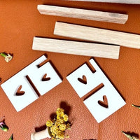 Silikon Gießform Herzsitzbank mit Lehne von easy-sticks: Zwei Herzstützen aus Silikon und Holzlatten auf einer braunen Oberfläche angeordnet.