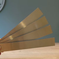 Eine Hand hält vier goldene Easy-Sticks von Easy-Sticks, 16 cm lang. Perfekt für vielfältige Bastelideen und kreative Anwendungen, um jeden Raum zu verschönern.