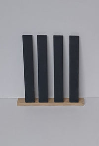 Die vier Anthrazit Easy-Sticks von Easy-Sticks, unter einem stilvollen Holzrahmen angeordnet. Vielseitig einsetzbar für individuelle Projekte.